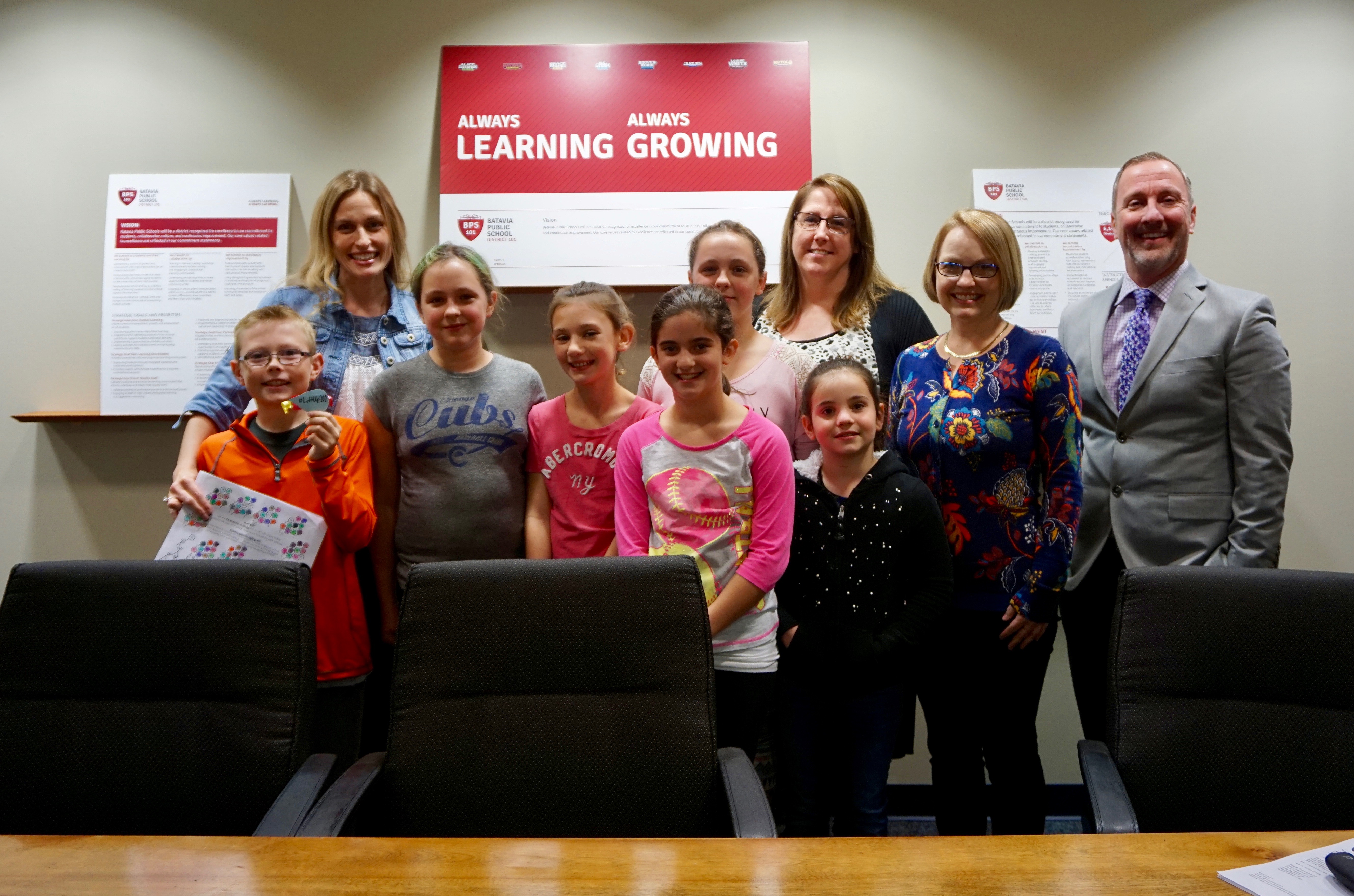 <p>(From left) Mary Jensen, AGS students, Special Education Paraprofessional Corrine Kornerup, LRC Director Tamra Ashby, and Principal Dr. Tim McDermott and several other AGS staff members were all instrumental in the launch of the #LiftUp101 Kindness Challenge.</p>
