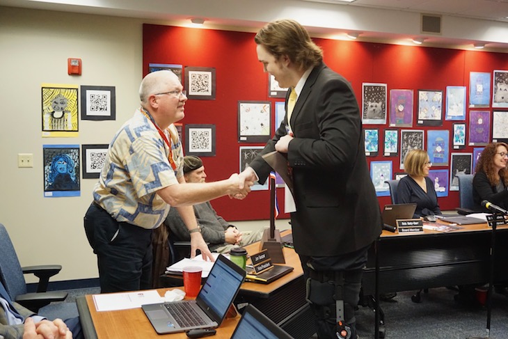 <p>BHS student athletes gave each Board Member an IHSA State Championship medal and a team photo. (Pictured: Jon Gaspar, BPS101 Board Vice President, and BHS senior, Nolan Eike. </p>
