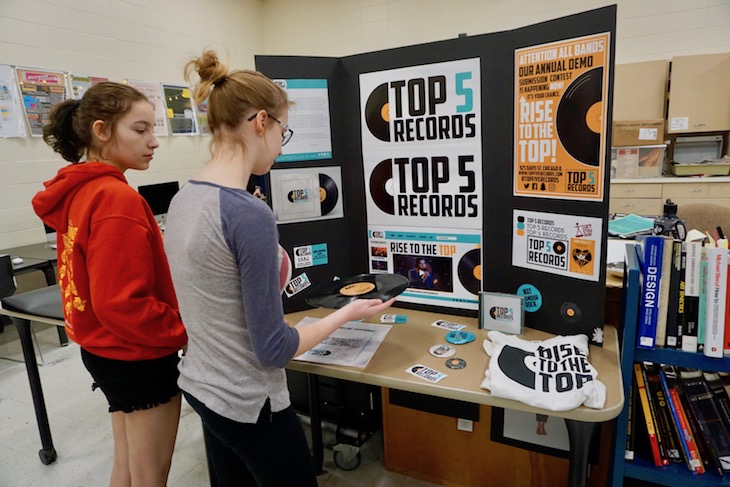 Batavia High School Graphics II students reviewing Haley Stein's graphic design portfolio.