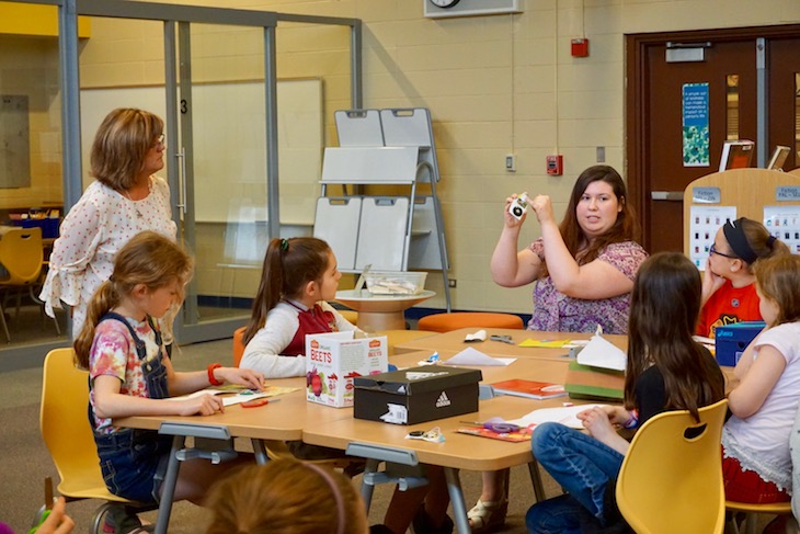 <p>NIU electrical and biomedical engineering student Laura Vogl explaining the “how” behind the music in a musical greeting card.</p>
