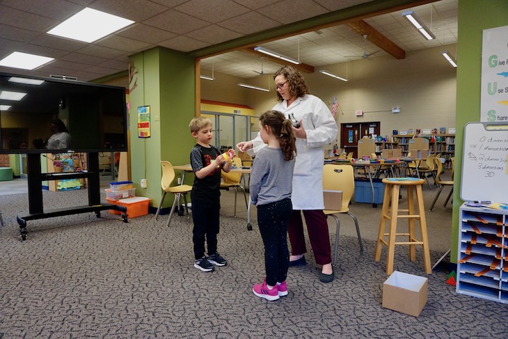 DuPage Children's Museum instructor Ms. McDougall showing students the difference between 2D and 3D shapes and how to make a 3D sphere.