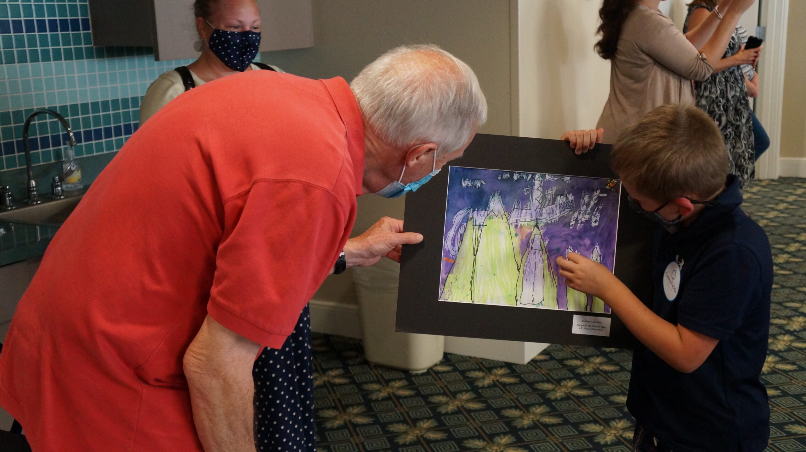 <p>Student explaining their art to a resident.</p>