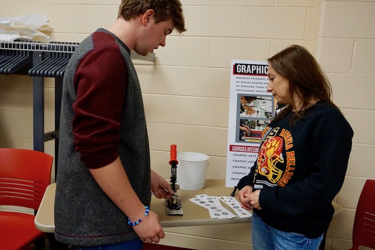 <p>Another multitasker … This BHS student was sharing information about the Graphics Arts program while creating custom buttons.</p>
