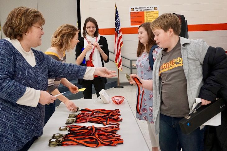 <p>After performing and getting scored by a judge, student musicians gave their score sheet to voluteers at the awards table to pick up their medals. </p>
